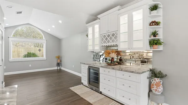 a kitchen with stainless steel appliances granite countertop a table chairs stove and refrigerator