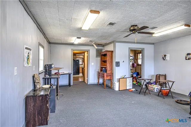a view of a livingroom with furniture and a ceiling fan