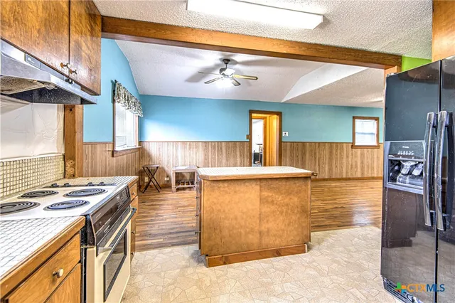a kitchen with stainless steel appliances granite countertop a stove a sink and a refrigerator