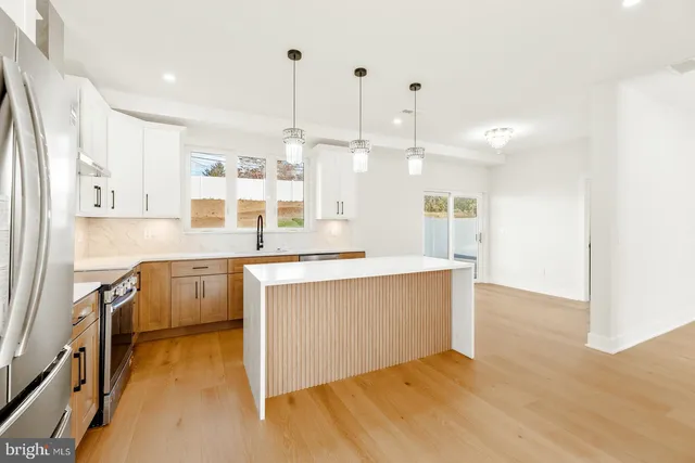 a kitchen with stainless steel appliances granite countertop a sink a stove and a refrigerator