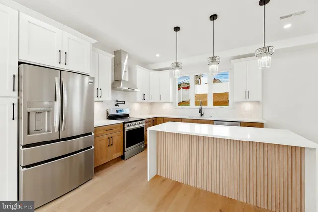 a kitchen with stainless steel appliances granite countertop a refrigerator a sink and a stove