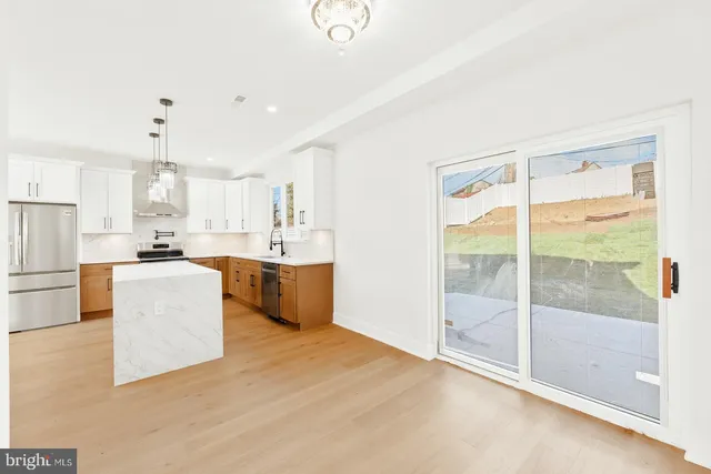 a view of kitchen with kitchen island a sink stainless steel appliances and cabinets
