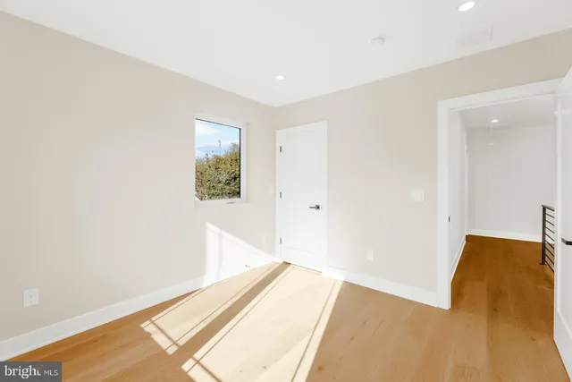 a view of a big room with wooden floor and windows