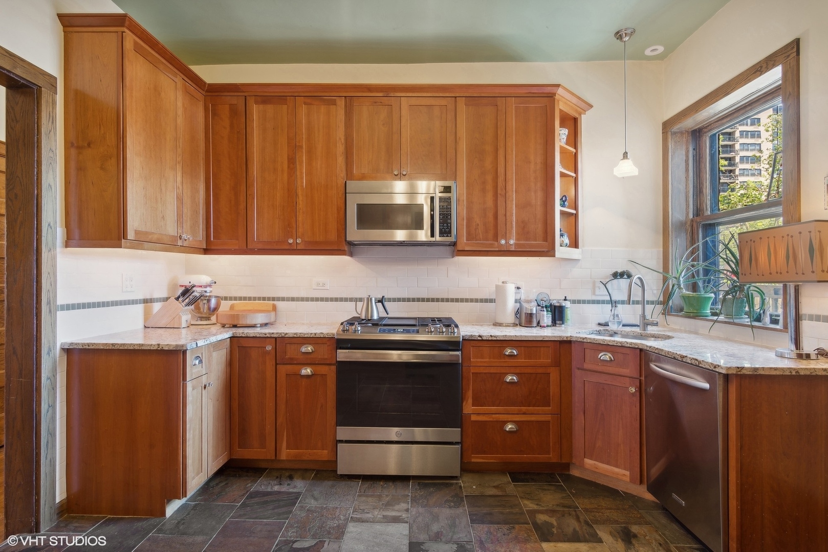 662 West Irving Park Road, Unit J4 Chicago, IL 60613 - Photo 17 of 31 a kitchen with stainless steel appliances granite countertop wooden cabinets and a sink