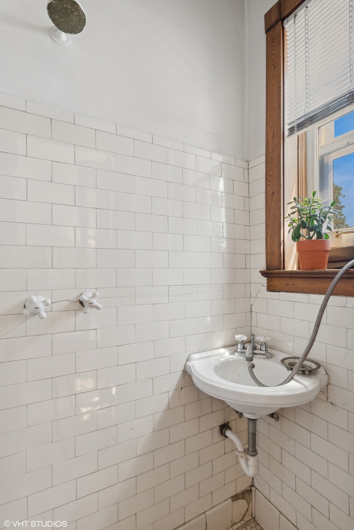662 West Irving Park Road, Unit J4 Chicago, IL 60613 - Photo 25 of 31 a bathroom with a sink a mirror and a shower