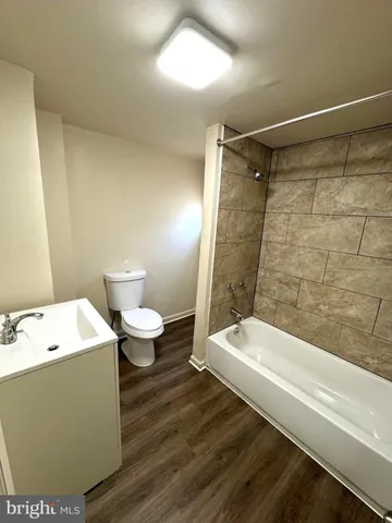 a bathroom with a white bath tub a toilet and a shower