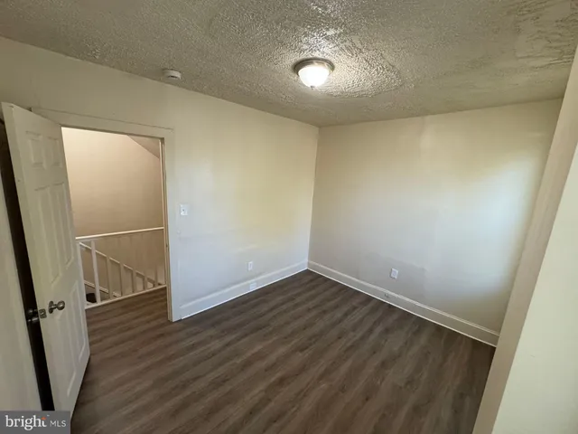 an empty room with wooden floor and entrance