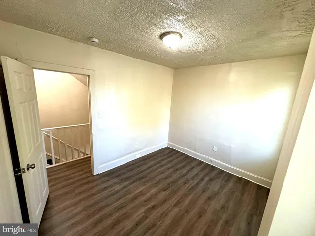 an empty room with wooden floor and entrance