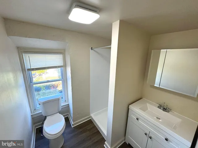 a bathroom with a granite countertop toilet sink and mirror
