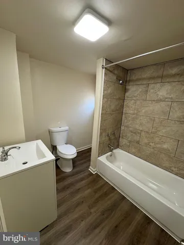 a bathroom with a white tub shower and a toilet