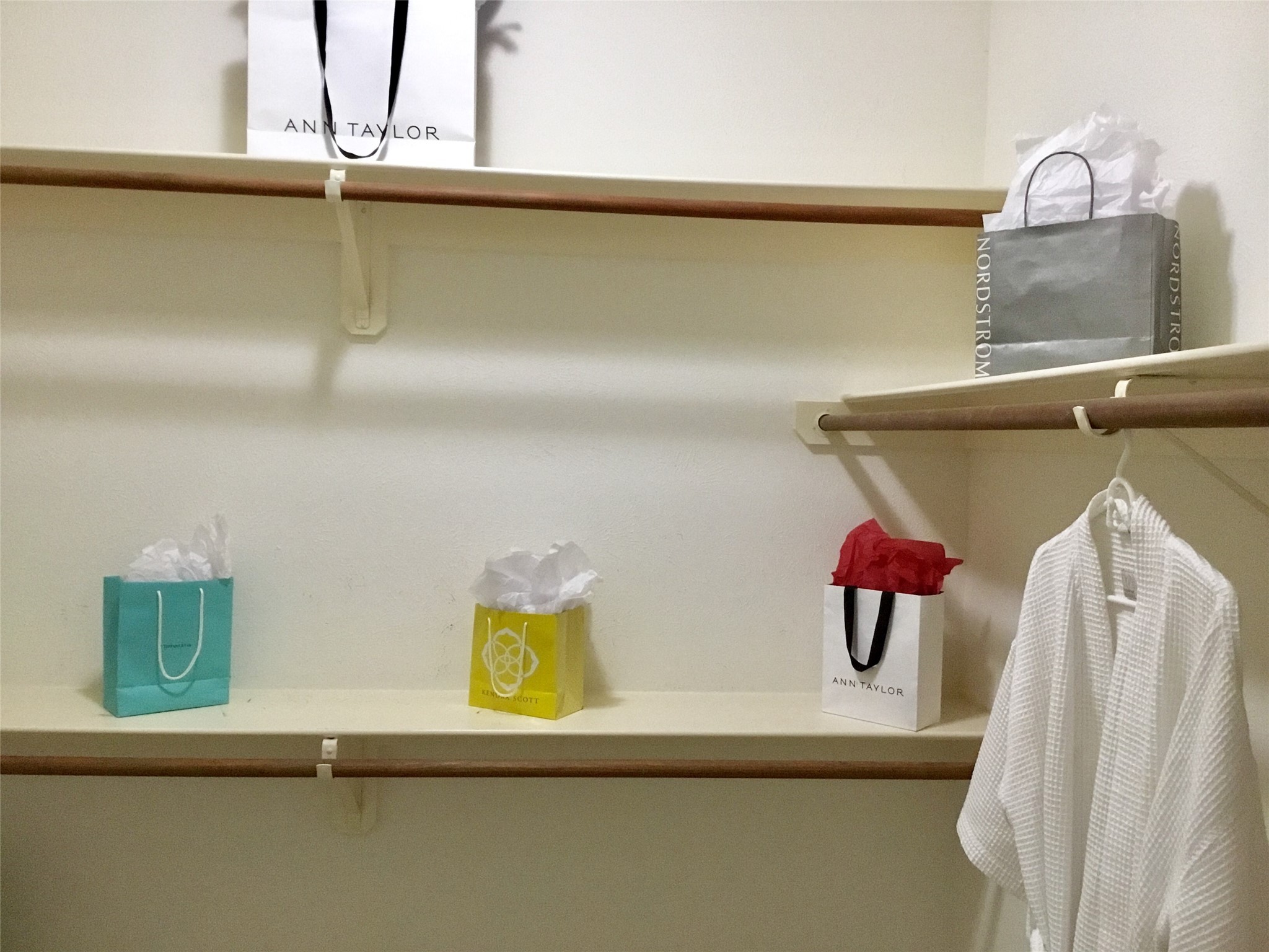 3 North Spiral Vine Circle Spring, TX 77381 - Photo 26 of 41 This photo shows a spacious walk-in closet with wooden shelves and hanging rods, ideal for organizing clothing and accessories.