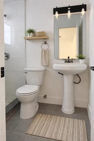a bathroom with a toilet sink and mirror