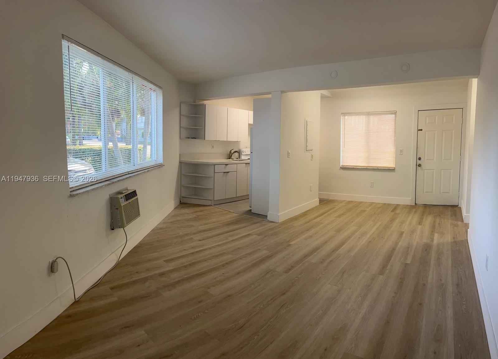 791 Southwest 64th Avenue, Unit 5 Miami, FL 33144 - Photo 7 of 9 a view of a kitchen with wooden floor and a window