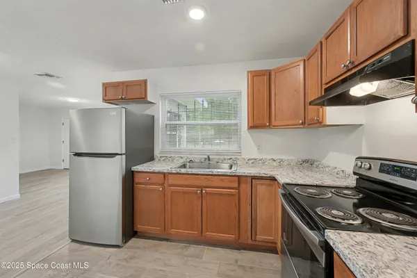 a kitchen with stainless steel appliances granite countertop a refrigerator sink stove and microwave
