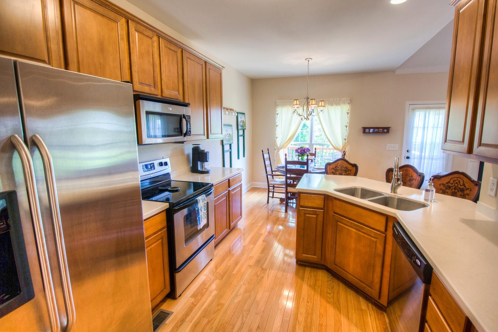 7084 Red Apple Road Antioch, TN 37013 - Photo 13 of 30 a kitchen with stainless steel appliances granite countertop a refrigerator a sink dishwasher a stove and white countertops with wooden floor