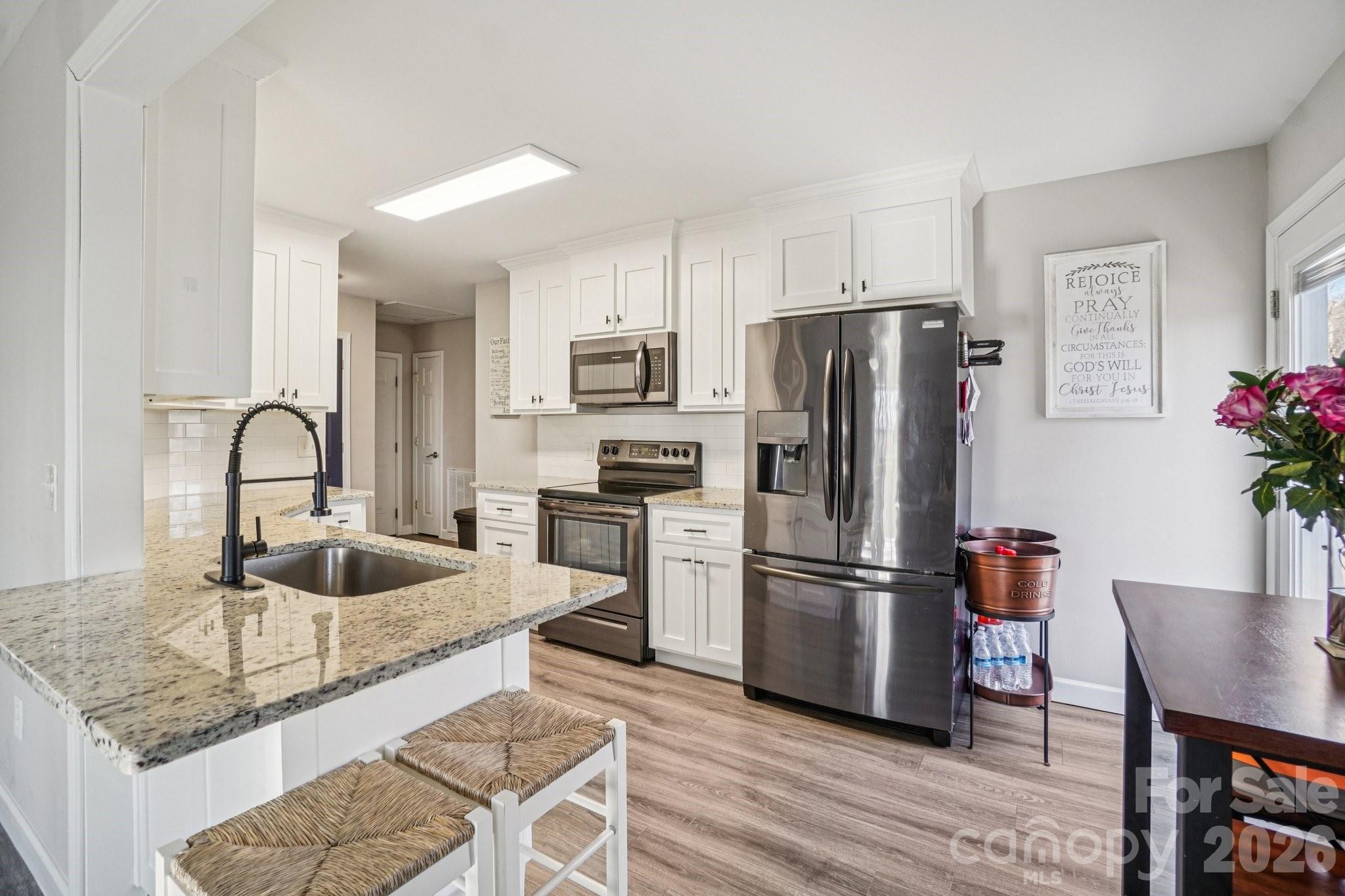 178 Rowe Court Hendersonville, NC 28792 - Photo 6 of 21 a kitchen with granite countertop a refrigerator and a sink