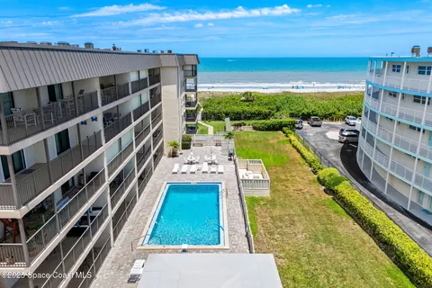 a view of two chairs and table in a balcony