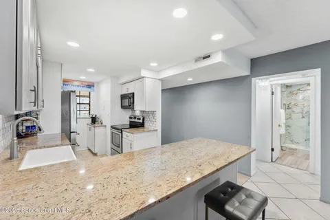 a view of kitchen with sink microwave and refrigerator