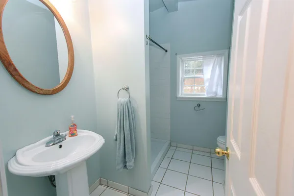 a bathroom with a sink a toilet and a mirror