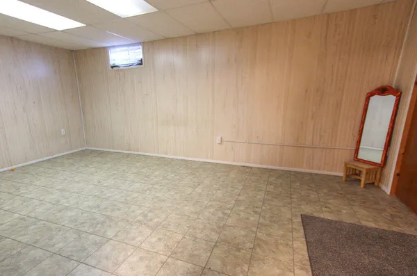 an empty room with a bench and a window