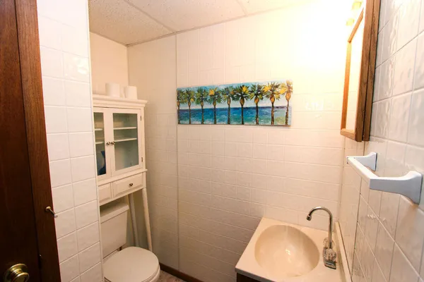 a bathroom with a toilet sink a mirror and shower