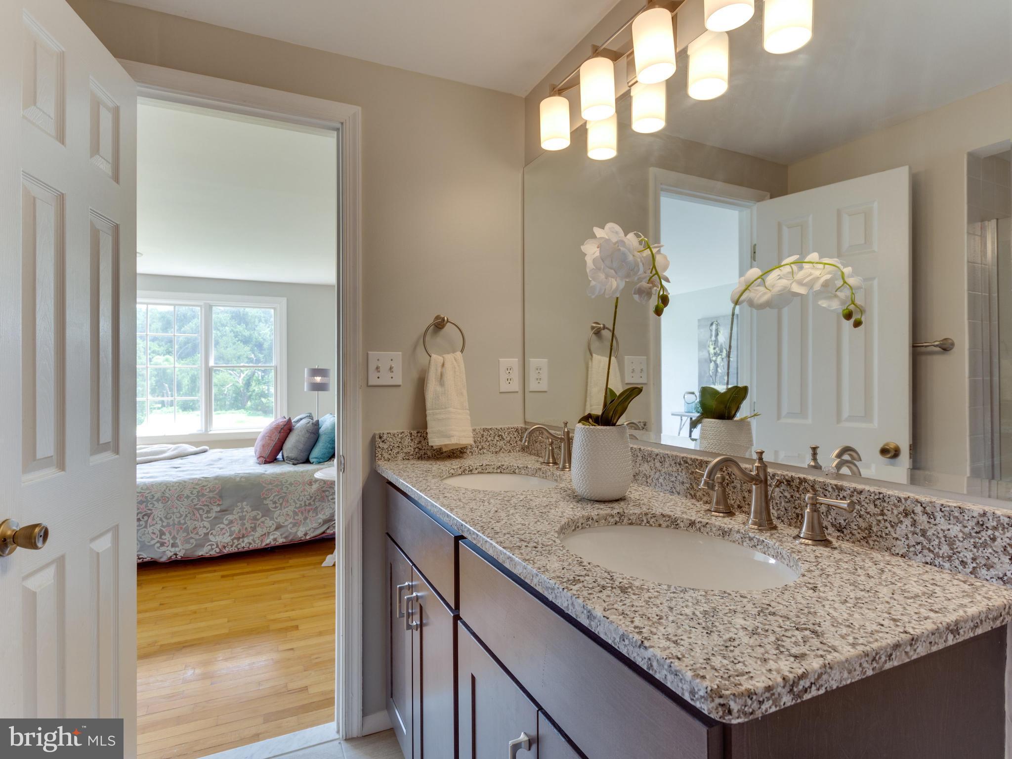 11617 Stuart Mill Road Oakton, VA 22124 - Photo 15 of 30 a en suite bathroom with a granite countertop sink and a mirror