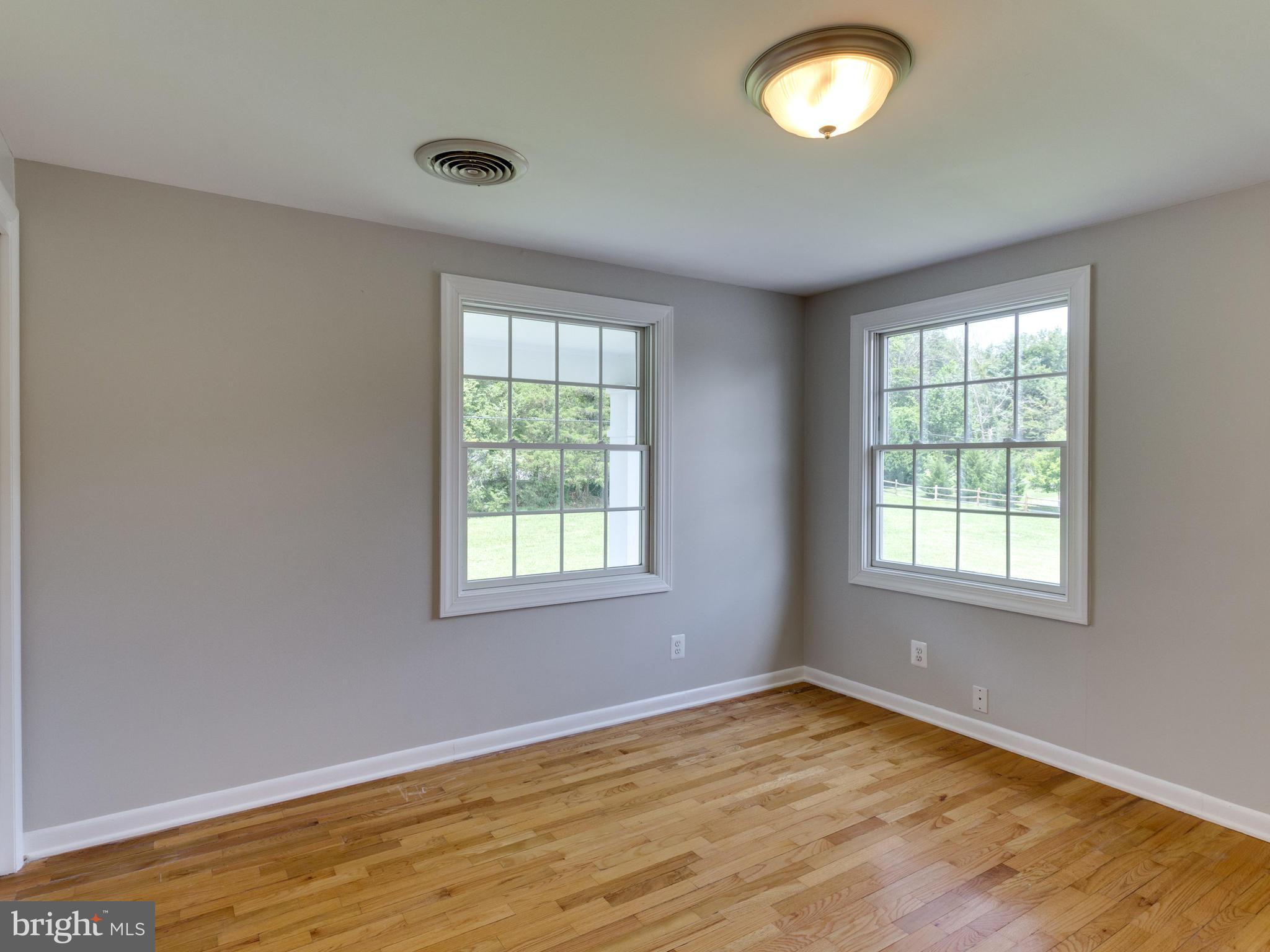 11617 Stuart Mill Road Oakton, VA 22124 - Photo 17 of 30 an empty room with wooden floor and windows