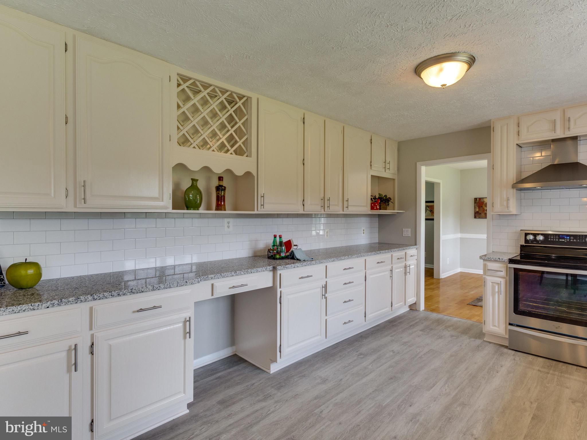 11617 Stuart Mill Road Oakton, VA 22124 - Photo 7 of 30 a kitchen with stainless steel appliances granite countertop a sink a stove and cabinets