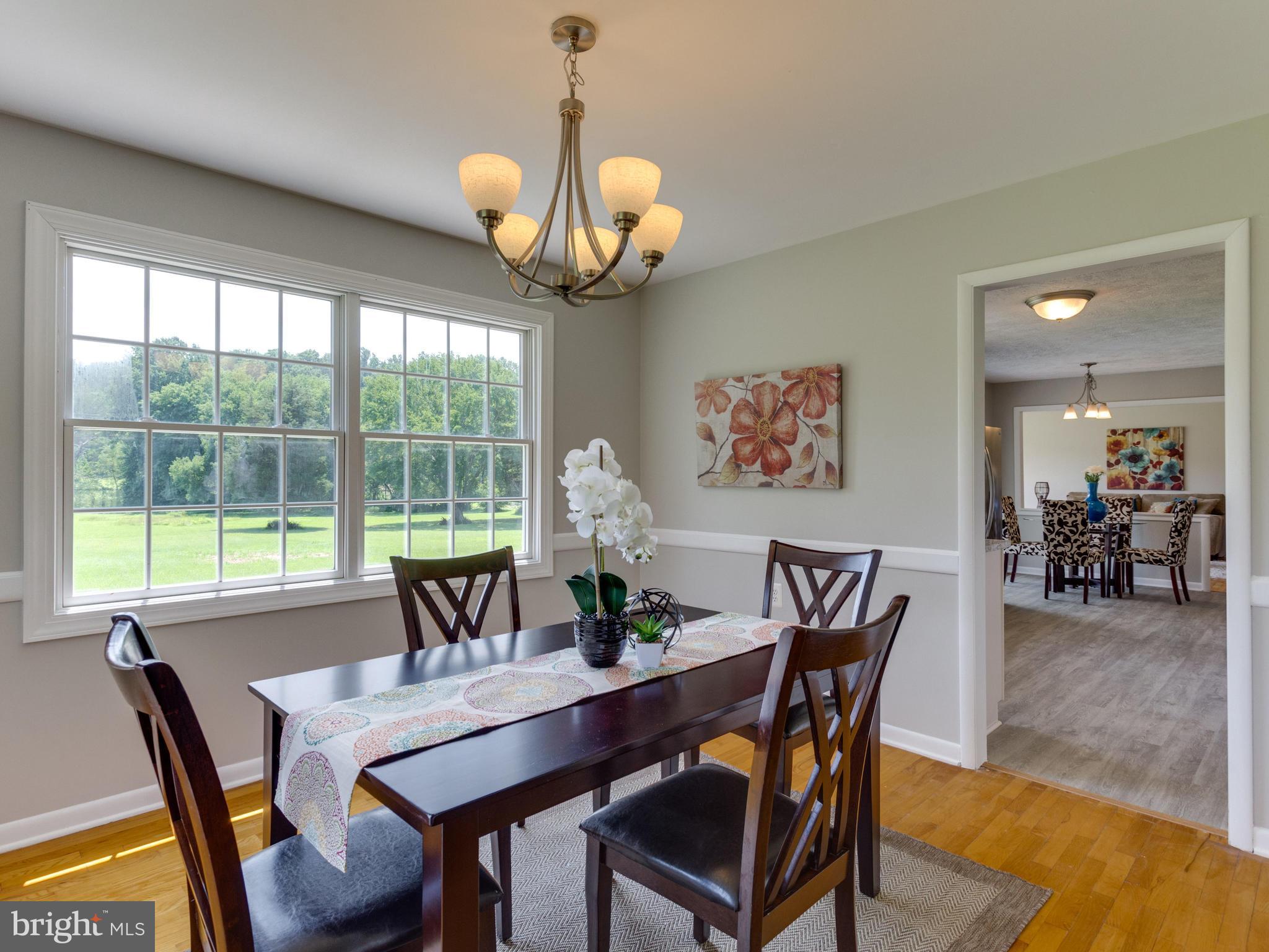 11617 Stuart Mill Road Oakton, VA 22124 - Photo 9 of 30 a view of a dining room with furniture wooden floor and chandelier
