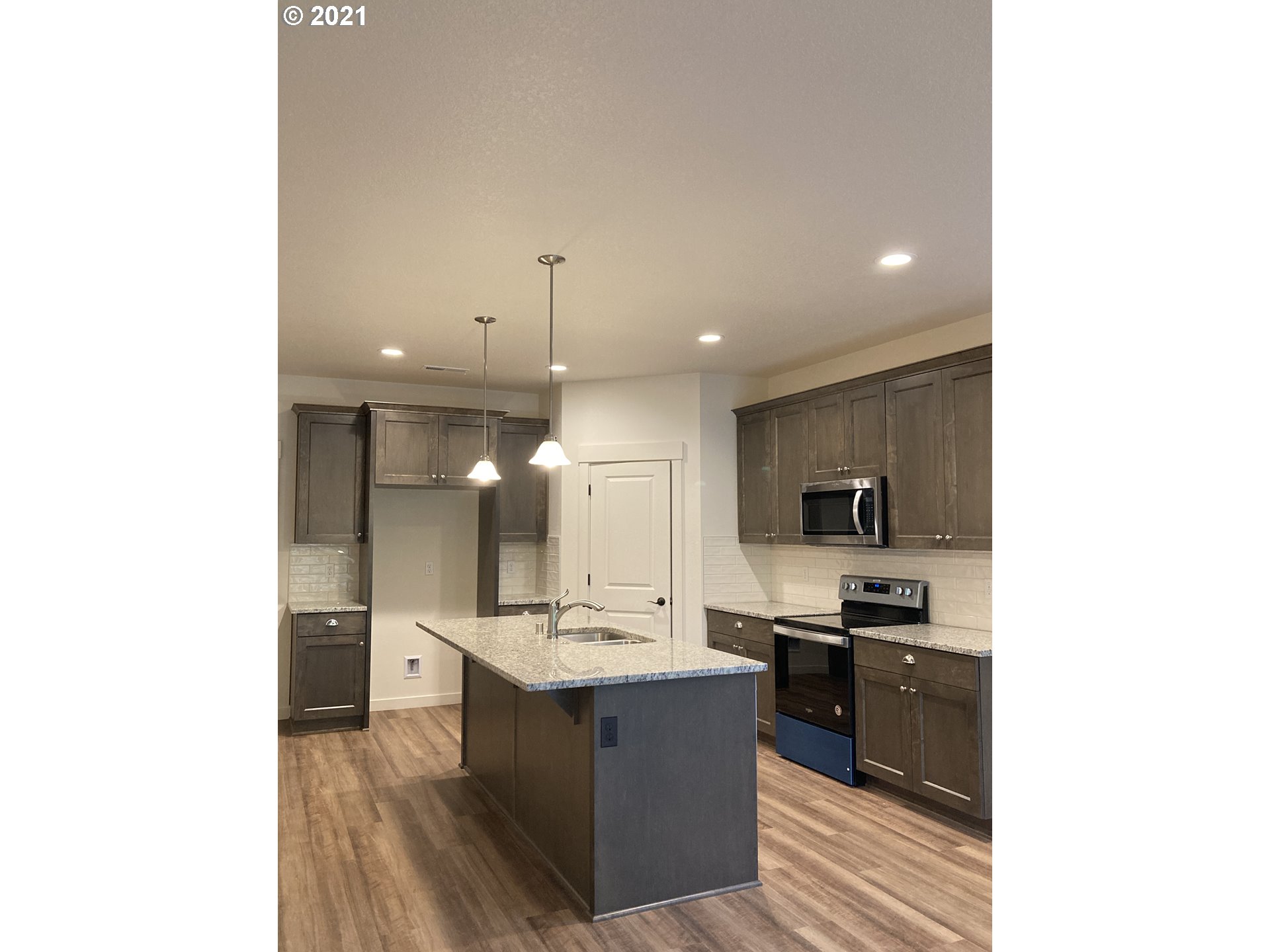 1251 South Union Place Ridgefield, WA 98642 - Photo 3 of 11 a large room with kitchen island a sink a counter top space and stainless steel appliances