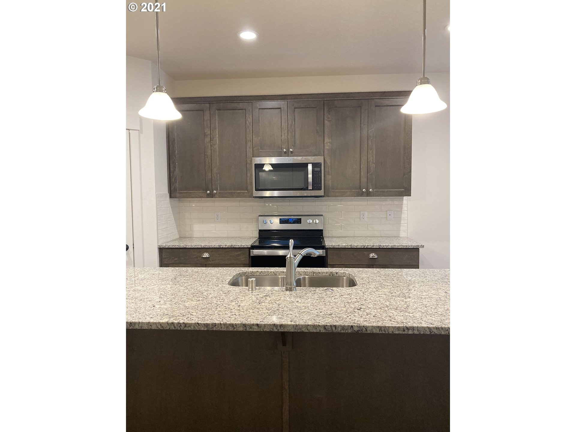1251 South Union Place Ridgefield, WA 98642 - Photo 5 of 11 a kitchen with granite countertop a sink and a stove
