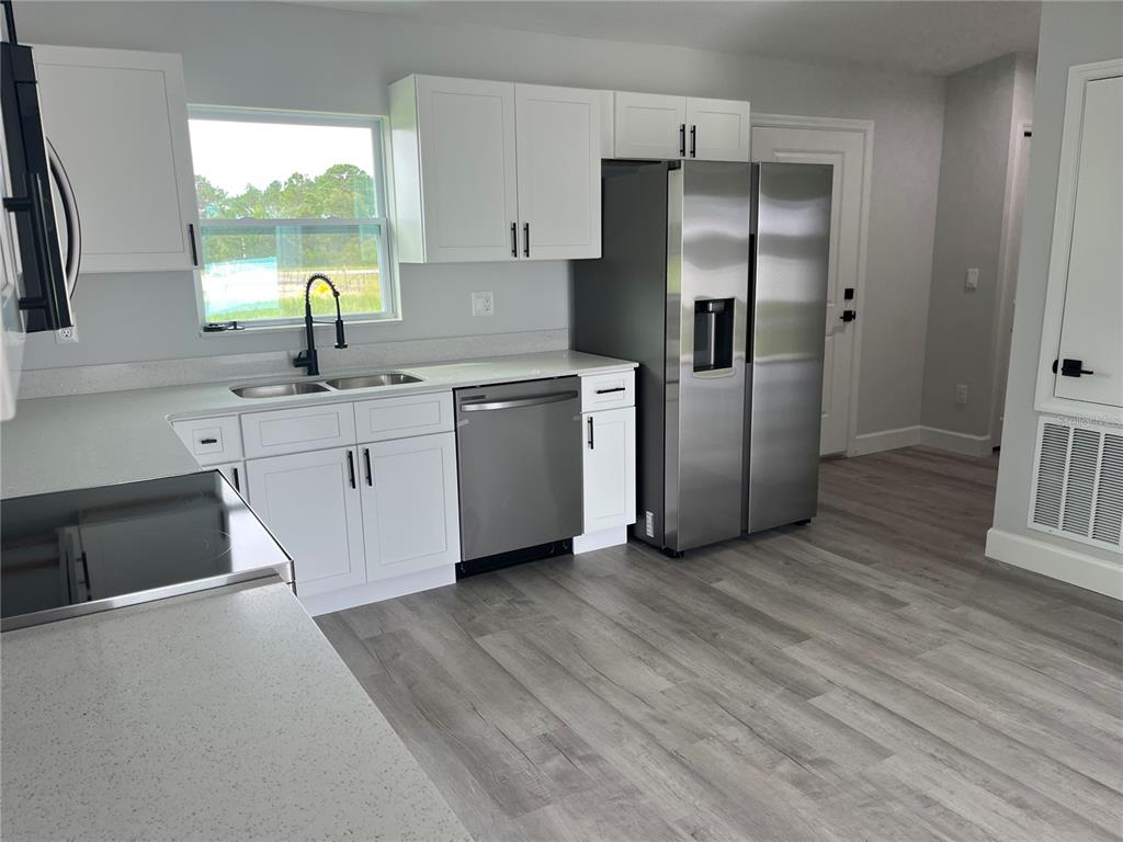 7209 Ancha Street Sebring, FL 33872 - Photo 5 of 20 a kitchen with stainless steel appliances granite countertop a refrigerator a sink and a stove