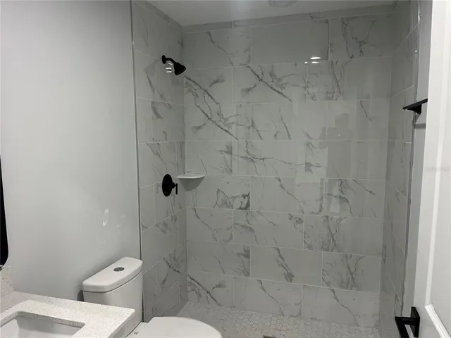 a bathroom with a toilet and a shower