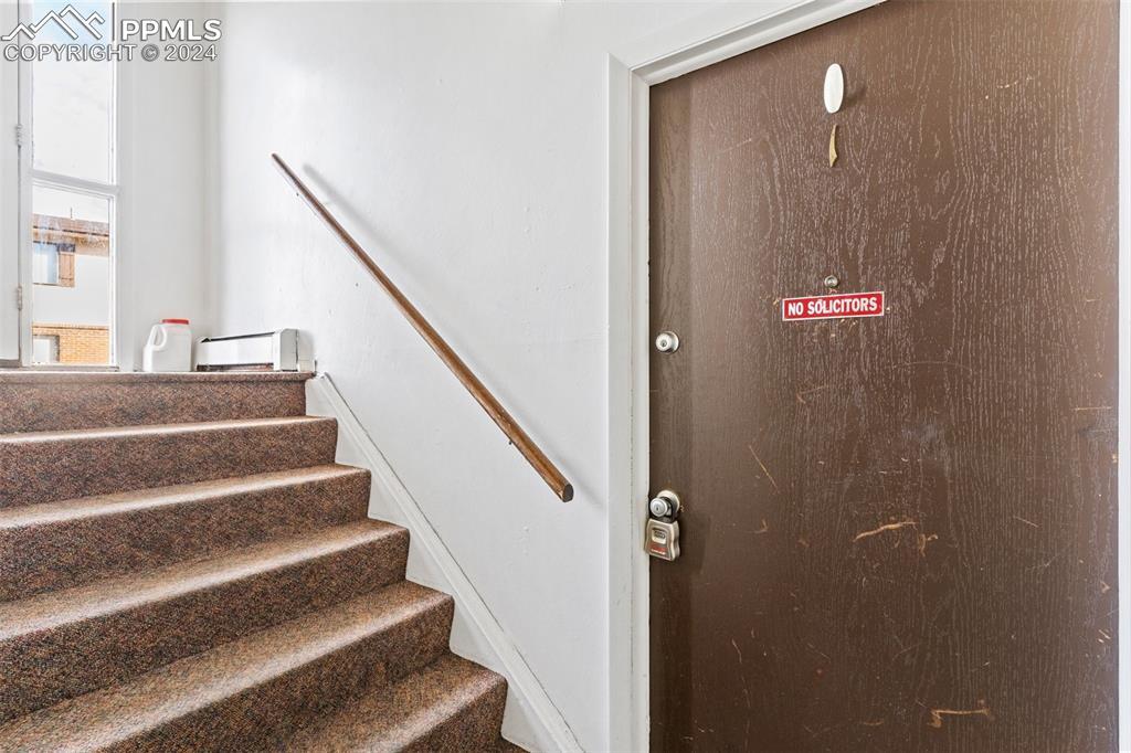 6602 Dublin Loop West, Unit 1 Colorado Springs, CO 80918 - Photo 20 of 23 a view of staircase with white walls and black door