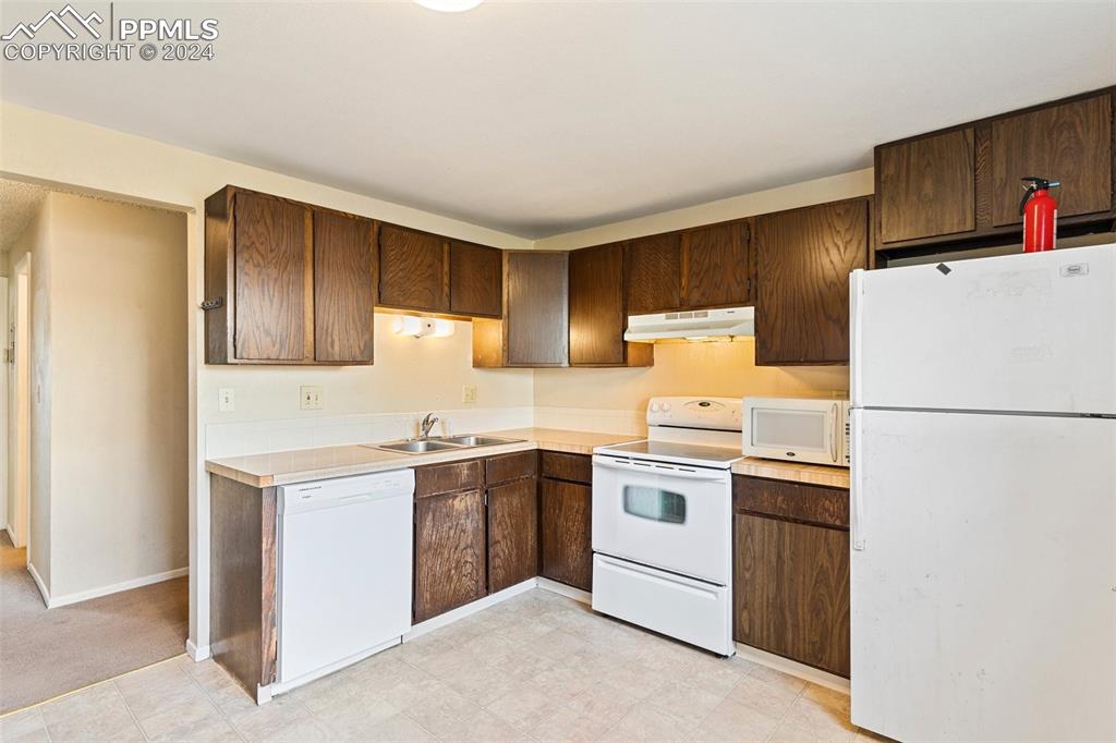 6602 Dublin Loop West, Unit 1 Colorado Springs, CO 80918 - Photo 9 of 23 a kitchen with a white cabinets and white appliances