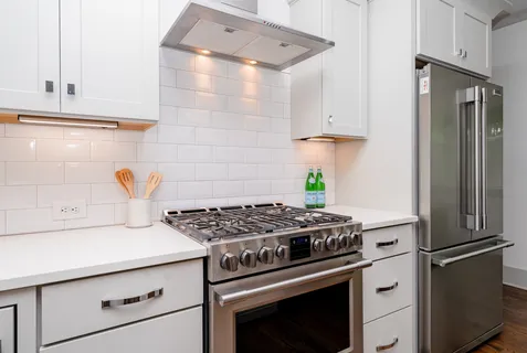 a kitchen with stainless steel appliances granite countertop a stove and a refrigerator