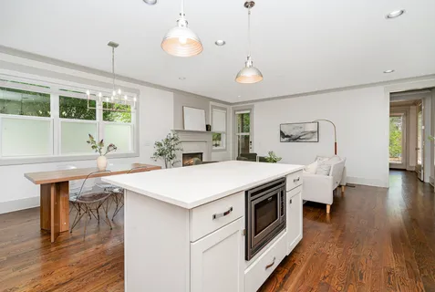 a kitchen with a stove and wooden floor