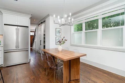 a kitchen with stainless steel appliances a dining table chairs and chandelier