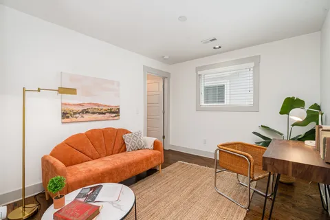 a living room with furniture a rug and a window