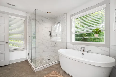 a white bath tub sitting next to a shower