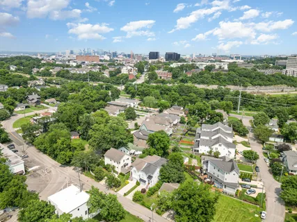 an aerial view of residential houses with outdoor space and trees