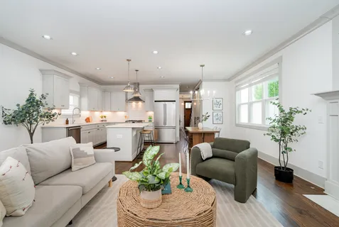 a living room with furniture kitchen and a potted plant