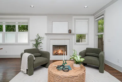 a living room with furniture a fireplace and a large window