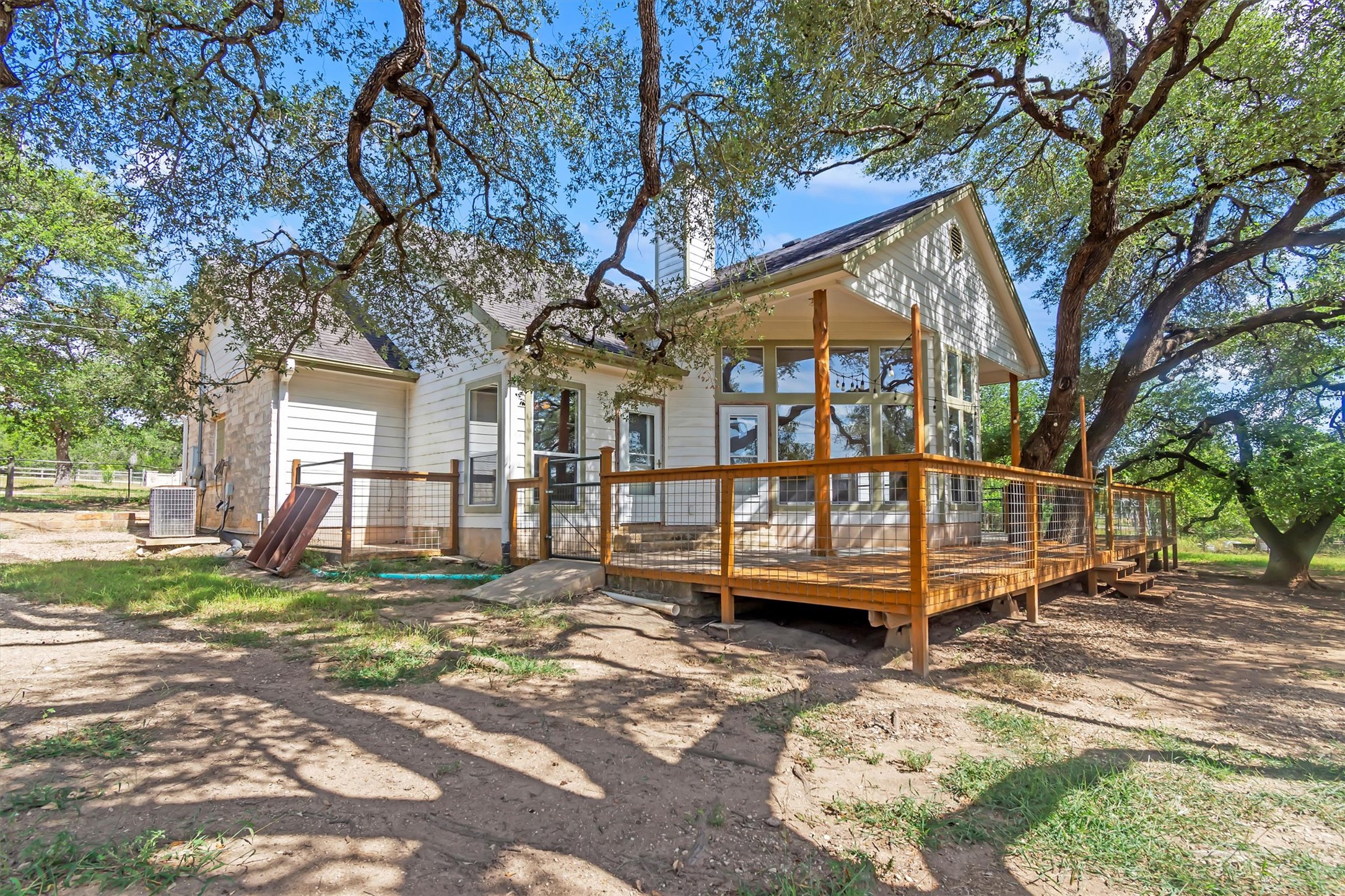 1120 Meadow Ridge Drive Austin, TX 78737 - Photo 29 of 40 A spacious wood deck extends from the charming siding exterior, shaded by mature trees.