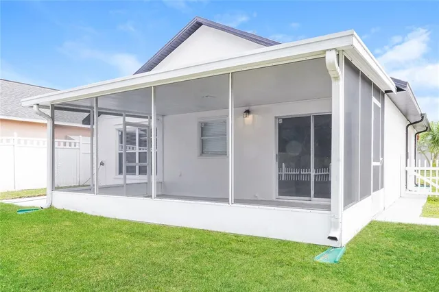 a backyard of a house with large windows and a garden