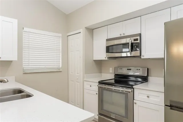 a kitchen with white cabinets and stainless steel appliances