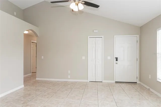 an empty room with fan and entrance