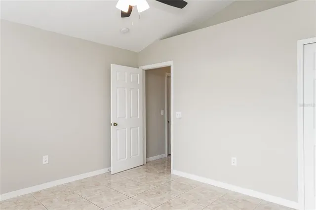 an empty room with a chandelier fan