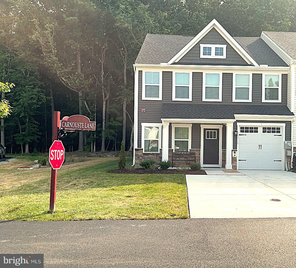 a front view of a house with a garden and trees