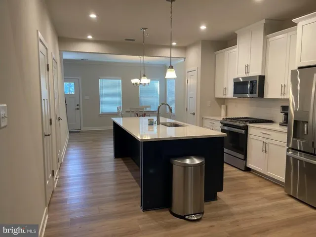 a kitchen with kitchen island granite countertop a sink appliances and cabinets